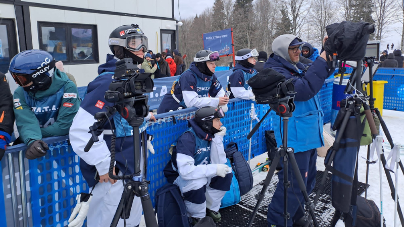Åkare och tränare kollar på tävlingen under finalomgångarna. 