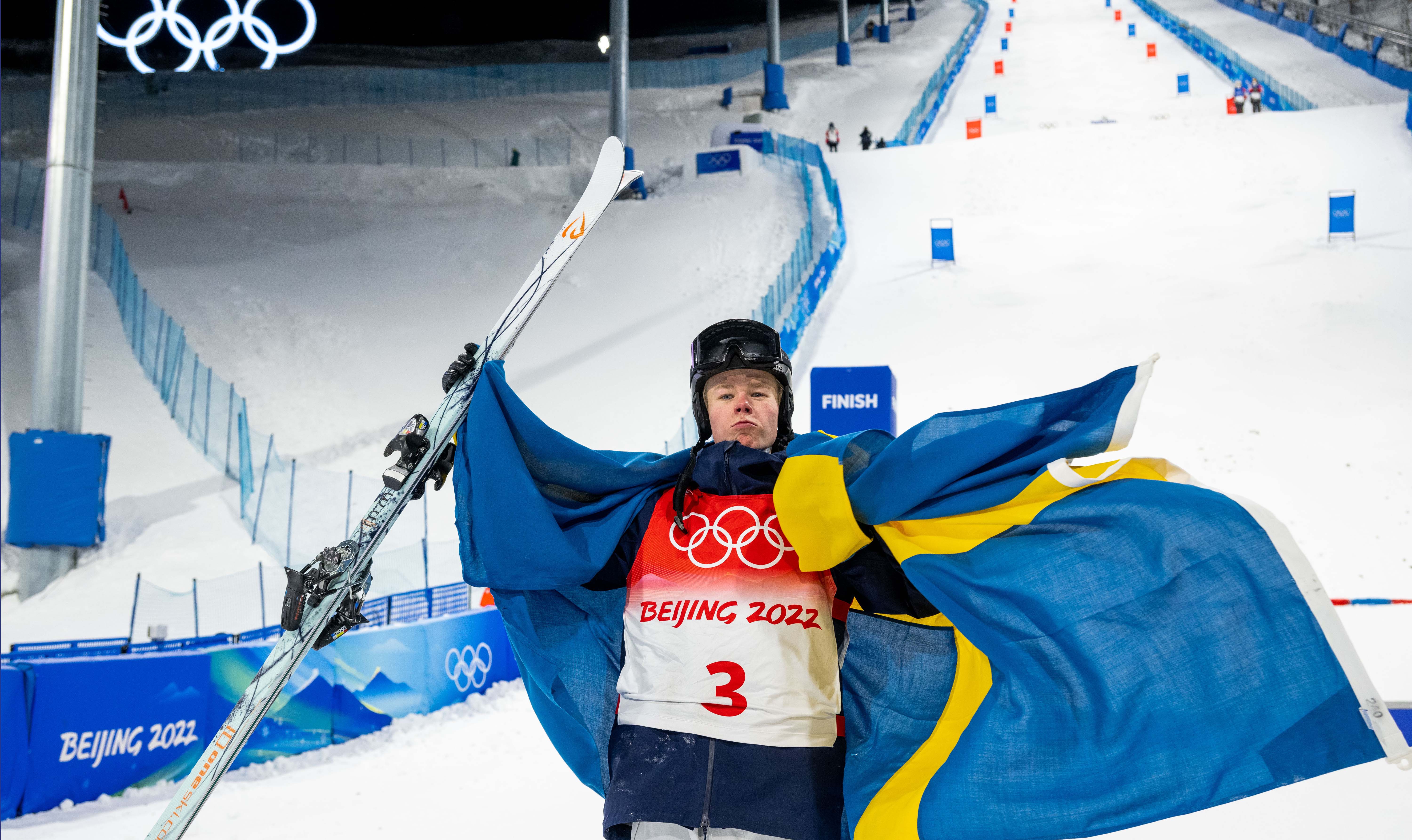 Walter Wallberg med svensk flagga på axlarna firar OS-guldet i Peking 2022